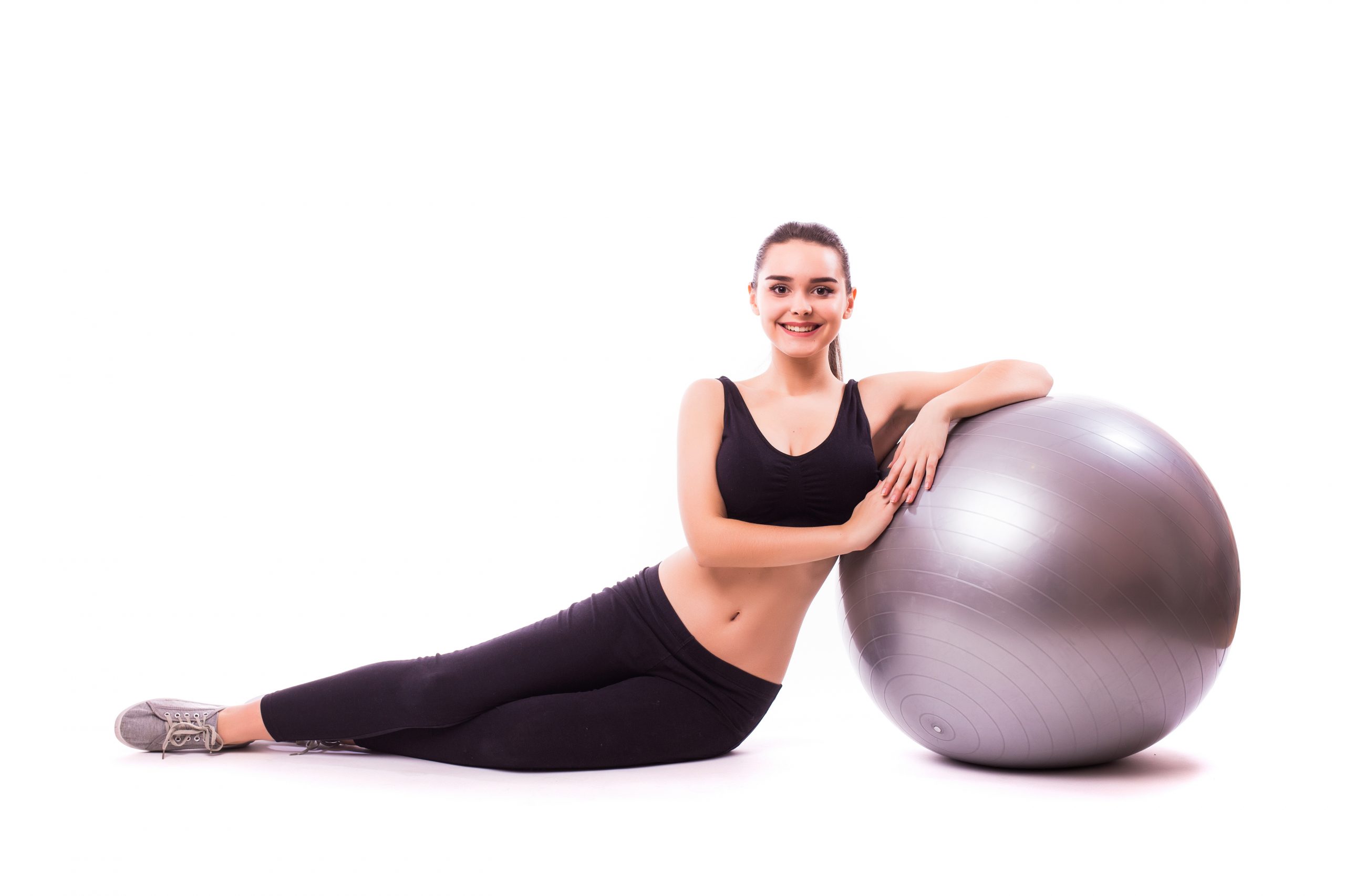 Beautiful young fitness woman with gym ball exercising, isolated on white background Beautiful young woman with gym ball exercising, isolated on white background